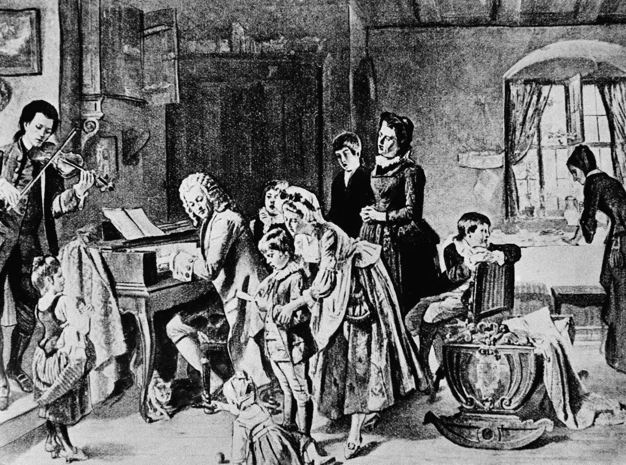 Johann Sebastian Bach z dziećmi w muzycznym domu. Syn gra na skrzypcach, ojciec przy klawikordzie, a reszta rodziny słucha.