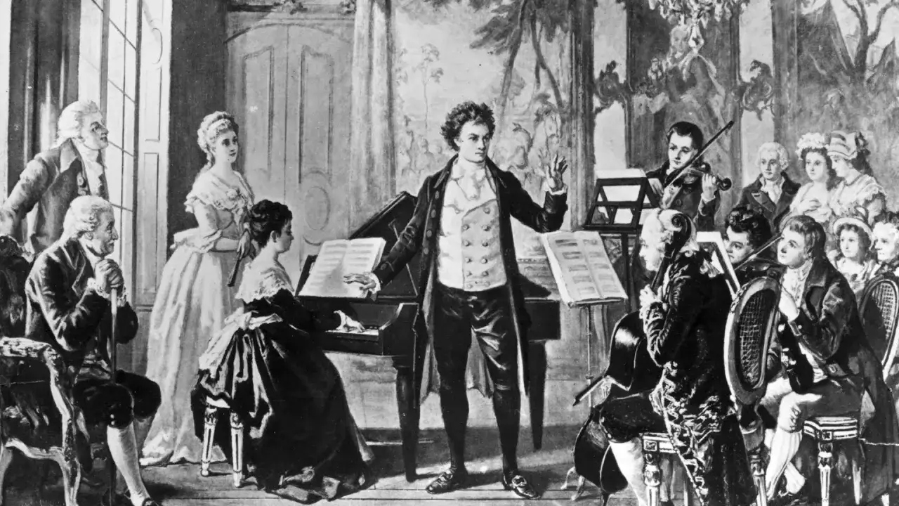 Ludwig van Beethoven prezentacja: kompozytor dyryguje orkiestrą i pianistką przy fortepianie.