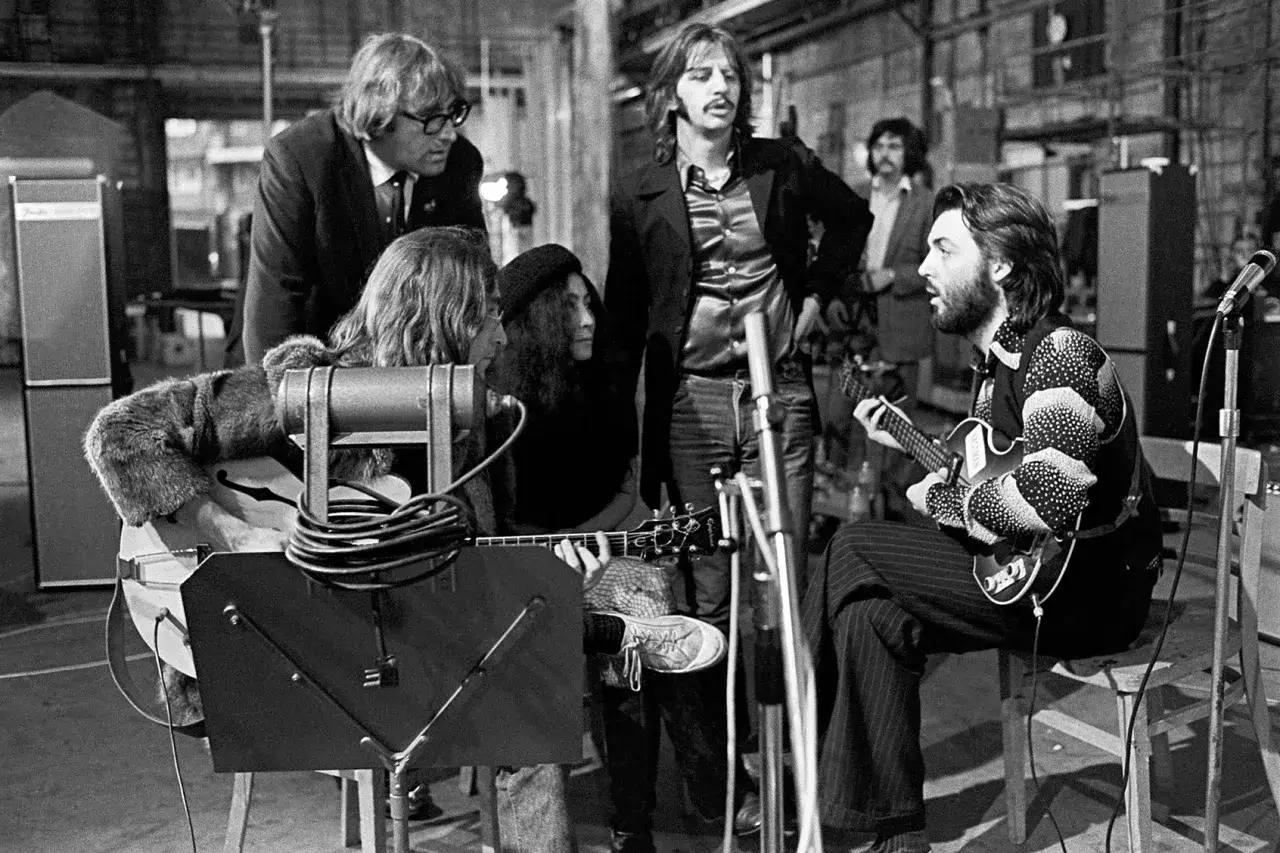 The Beatles, wraz z Yoko Ono, nagrywają muzykę. Paul McCartney gra na gitarze, John Lennon i George Harrison również trzymają instrumenty. To chwile, które zostaną z nami na zawsze.