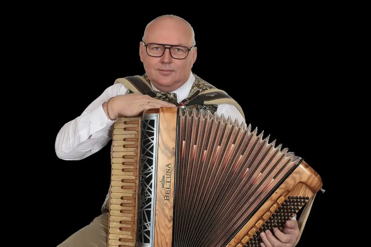 Mężczyzna w okularach z akordeonem marki BELTUNA.