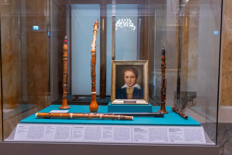 Portret młodego Beethovena i instrumenty muzyczne, które mogły być związane z miejscem urodzenia Ludwika van Beethovena.