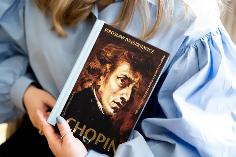 Kobieta trzyma książkę o Chopinie. Portret kompozytora na okładce. Piękna muzyka Chopina.